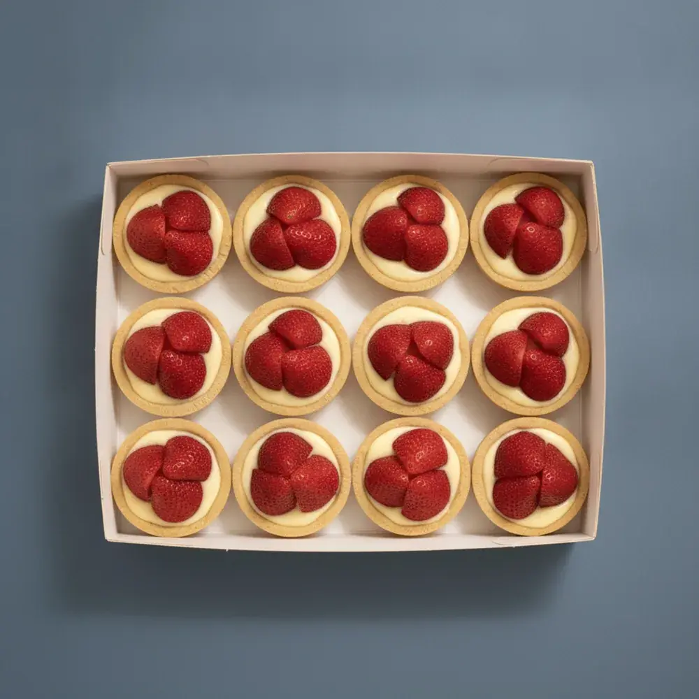 An open box of twelve French strawberry custard tarts, seen from above